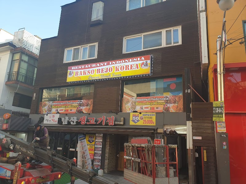 Exterior of Bakso Bejo Korea restaurant in Seoul, Indonesia-themed signage on a dark wood-paneled building with construction work