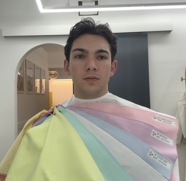 A person undergoing a personal color analysis session with pastel fabric swatches held against them in a studio