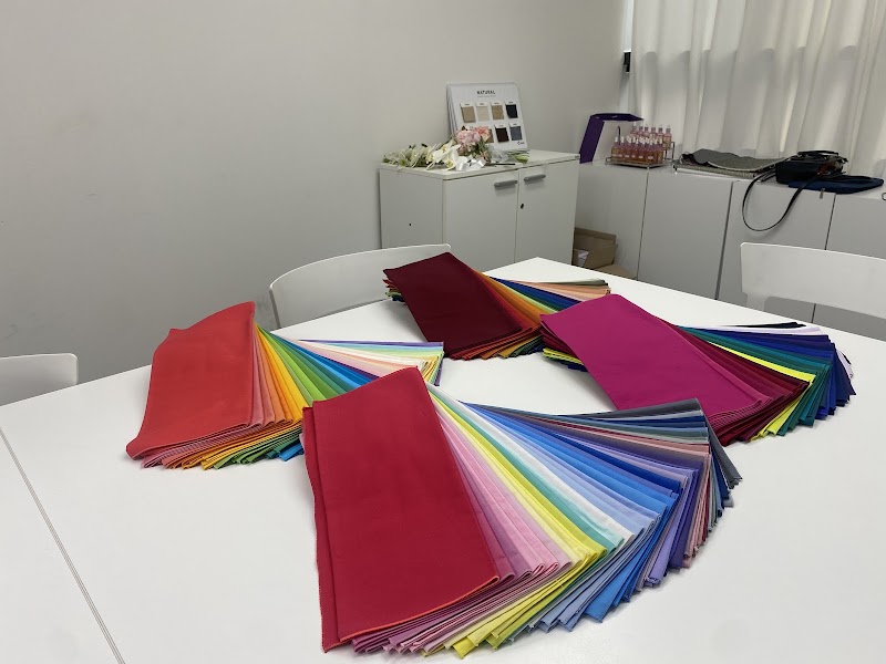 Multicolor fabric drapes arranged on a white table for a personal color analysis session