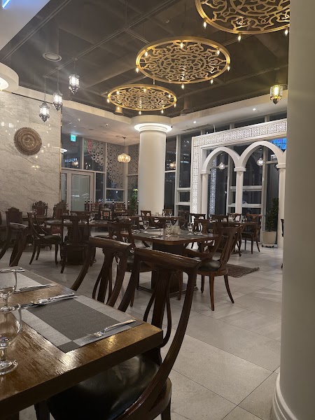 Interior of Saffron restaurant featuring elegant Middle Eastern inspired decor, wooden tables, and ornate circular light fixtures