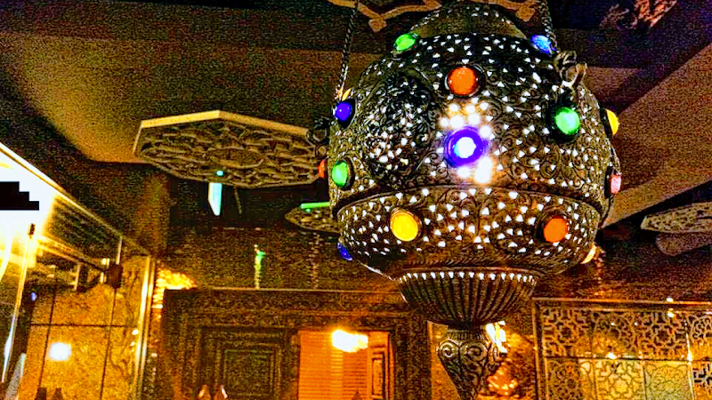 Intricate metal pendant lamp with colorful glass inserts inside Saffron restaurant in Seoul