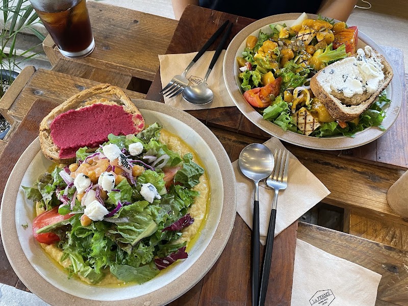 Two plates of fresh vegetable salads with toasted bread at a restaurant table
