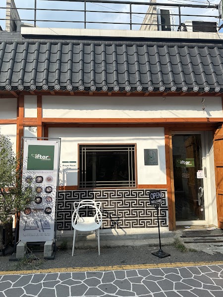 Street entrance with traditional tile roof and menu board at IFTAR