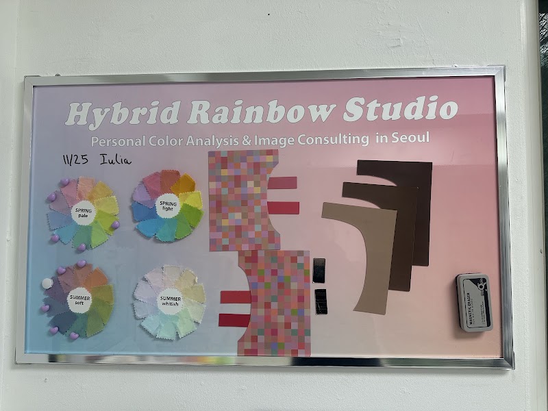 A metal framed information board for Hybrid Rainbow Studio displaying personal color analysis tools on a pink-to-blue gradient background.