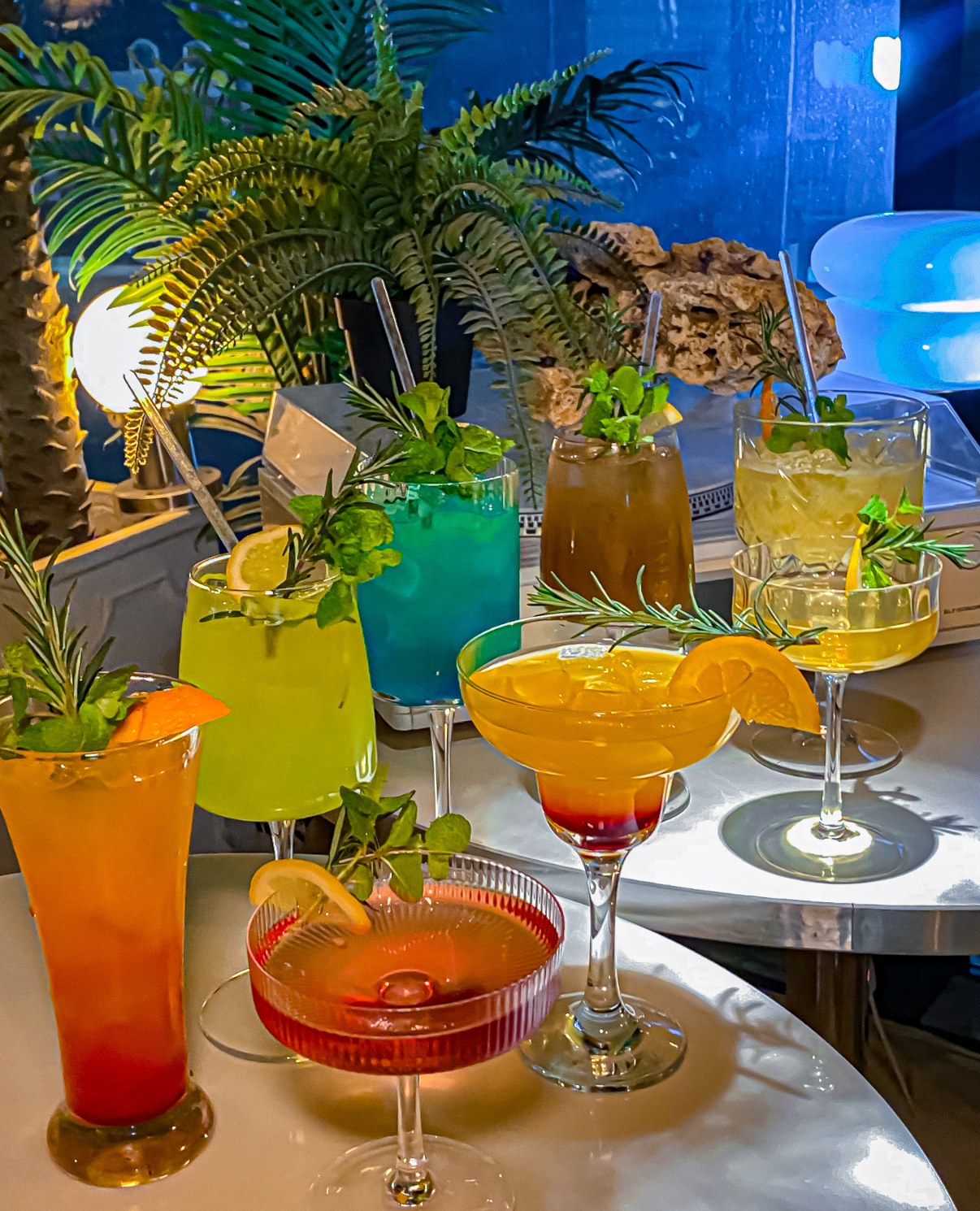 Colorful line of classic and craft cocktails on a metallic bar table
