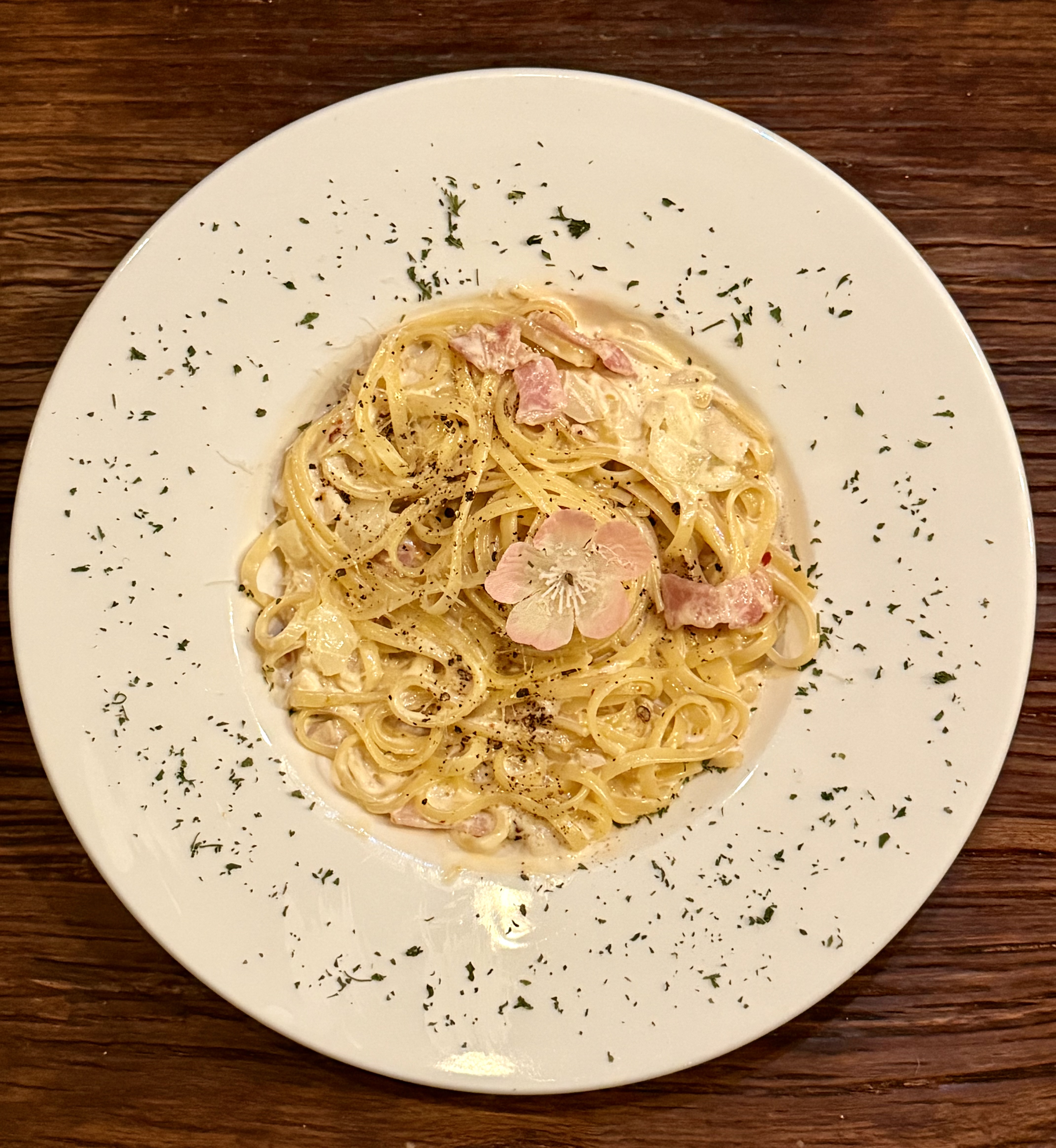 Creamy pasta topped with pepper and floral accent