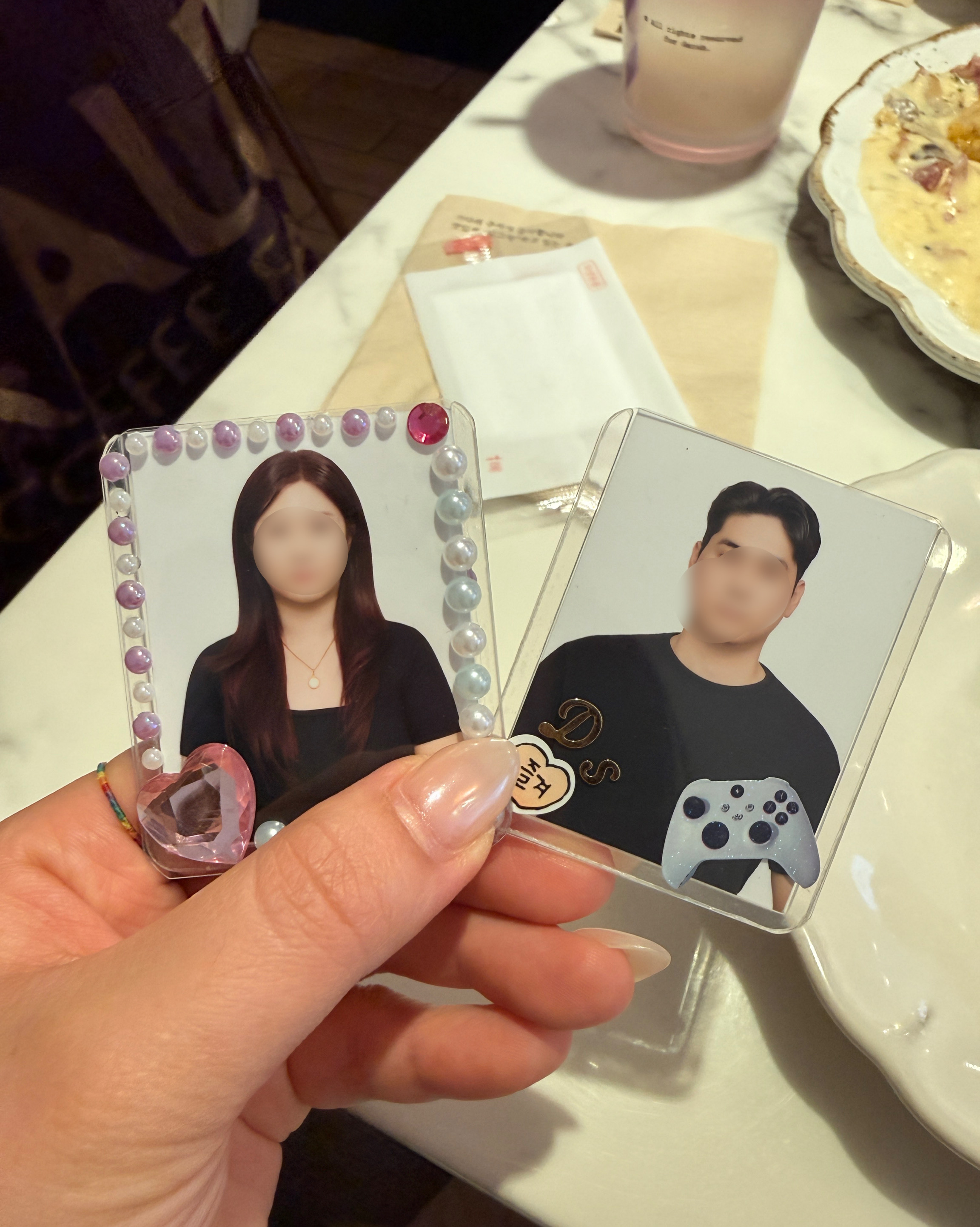 Two decorated portrait cards held in protective plastic top-loader cases