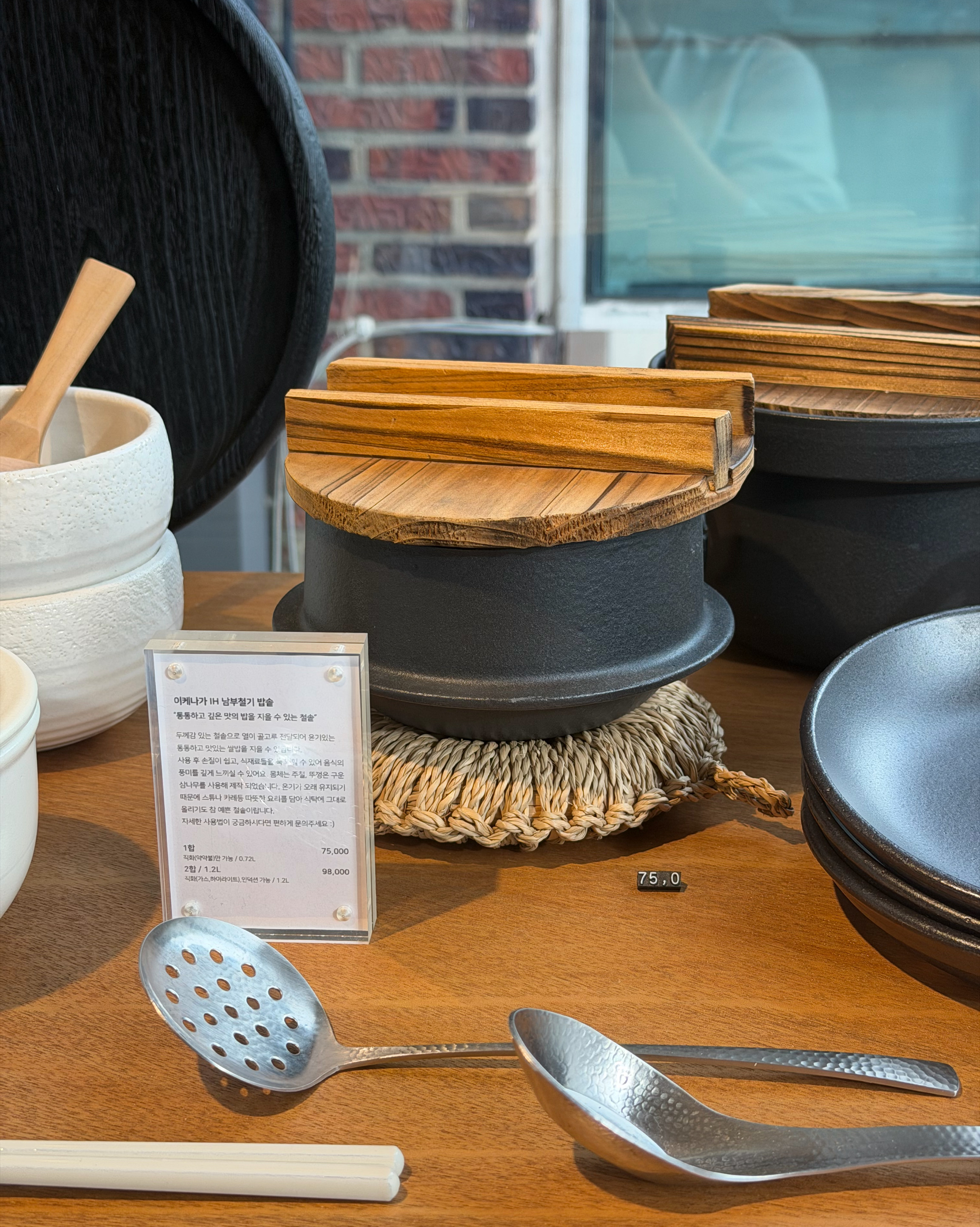 Cast iron pot with a wooden lid on a woven trivet.
