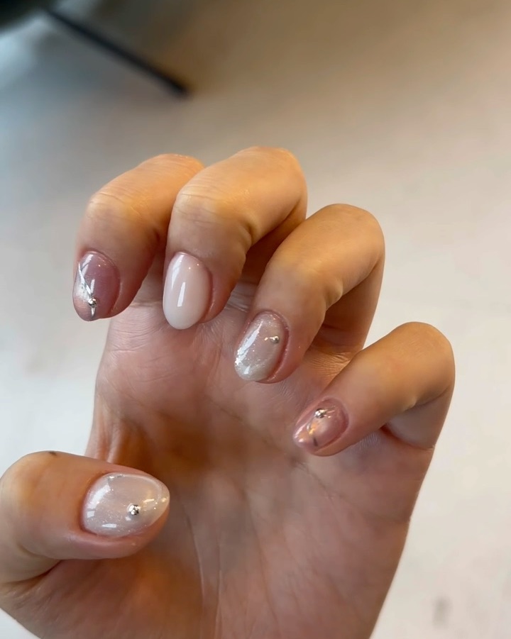 Translucent gel nails with metallic studs and magnetic shimmer