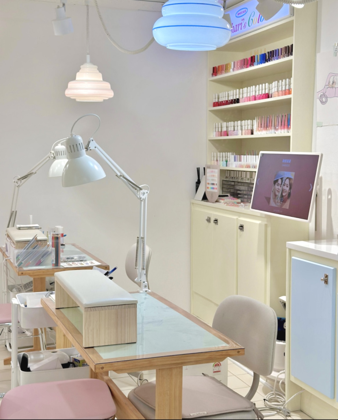 Clean workstation with nail polish display shelves and soft pastel interior at Nail Hari Hongdae