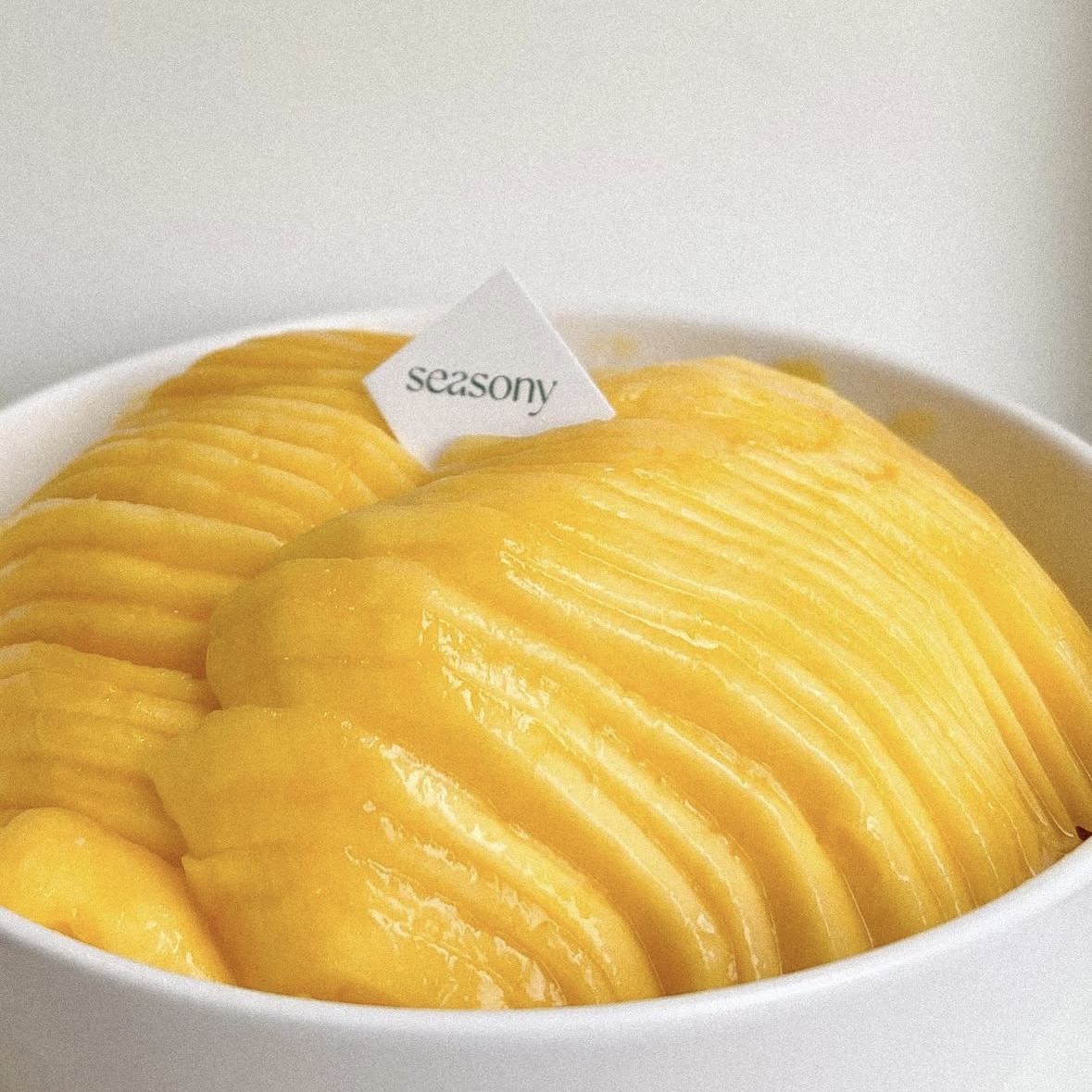 Close-up of fresh mango dessert bowl arranged with thin mango ribbons