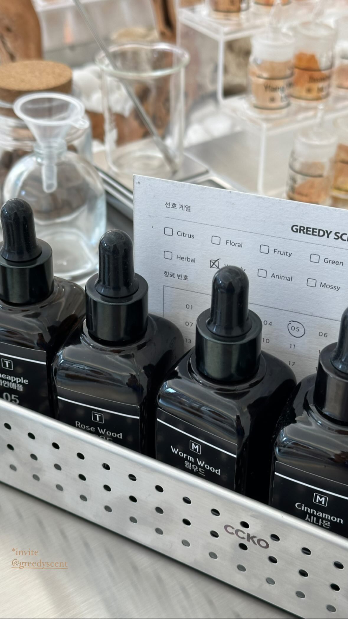 Glass amber perfume bottles and a scent preference card in the Greedy Scent studio