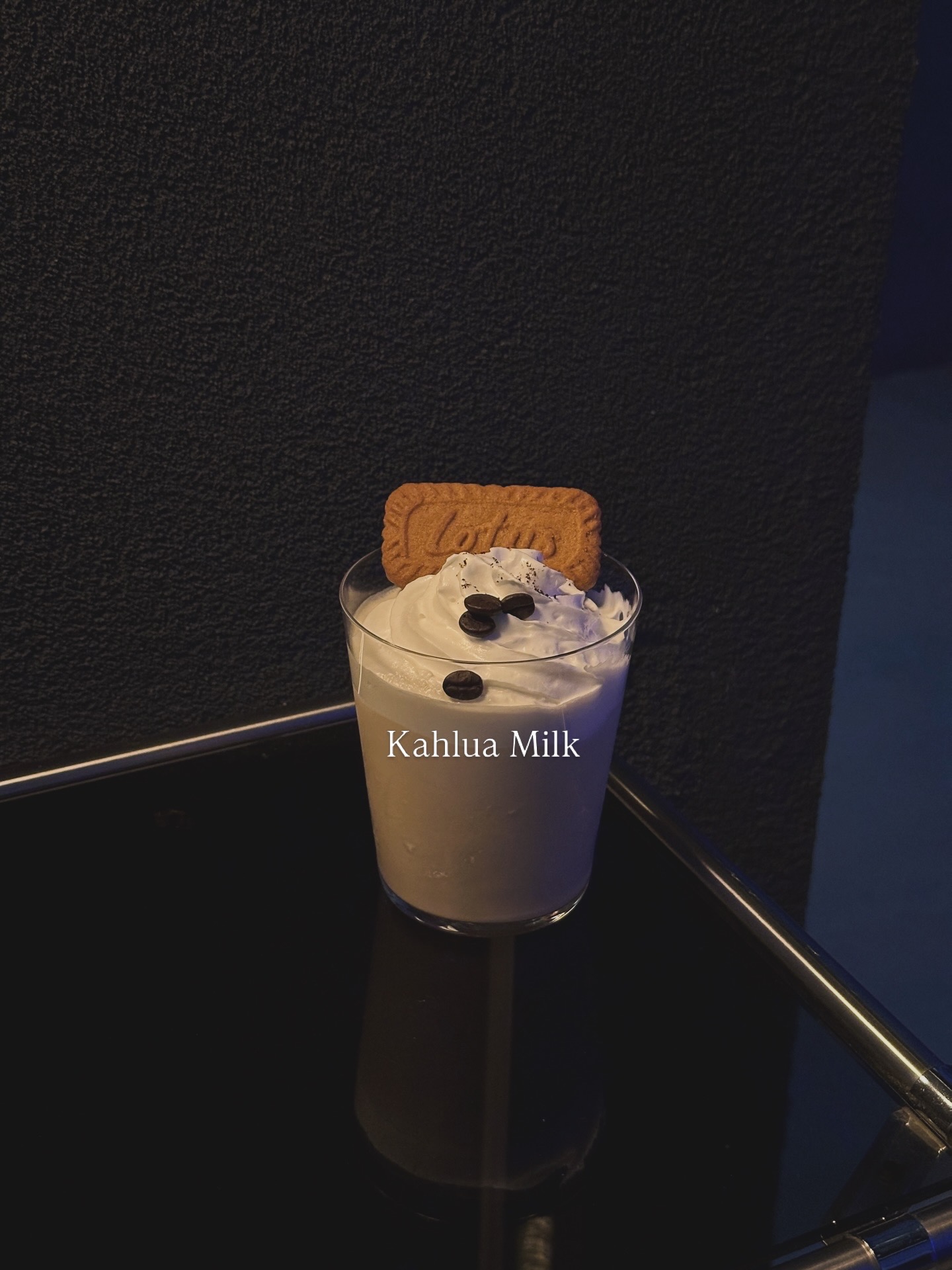 Kahlua Milk cocktail with whipped cream, roasted coffee beans, and Lotus biscuit