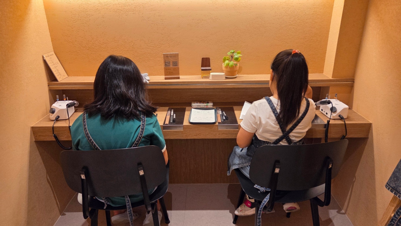 Two people crafting at wooden bench workstation in Studio 925
