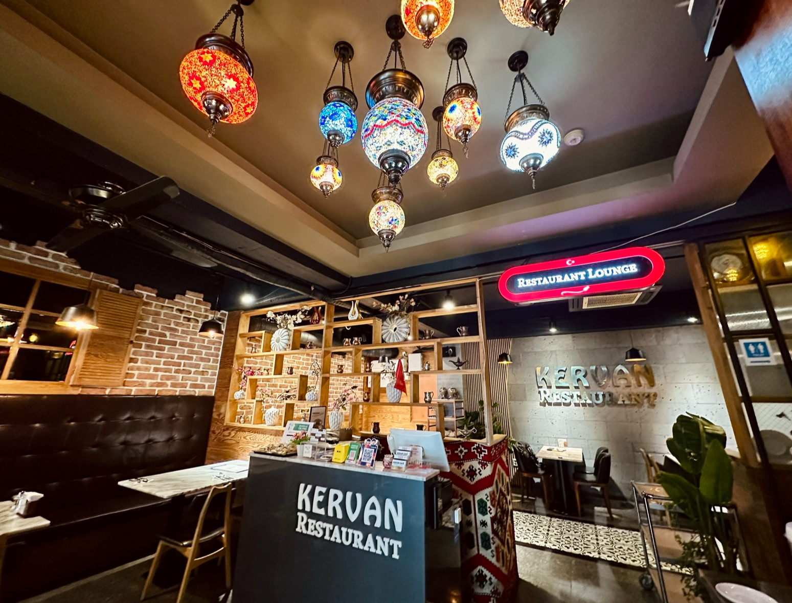 Interior of Kervan Restaurant in Seoul with decorative mosaic lamps and reception desk.