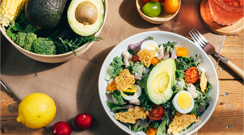 Fresh salad bowl flat lay with avocado, lemon, and seasonal produce