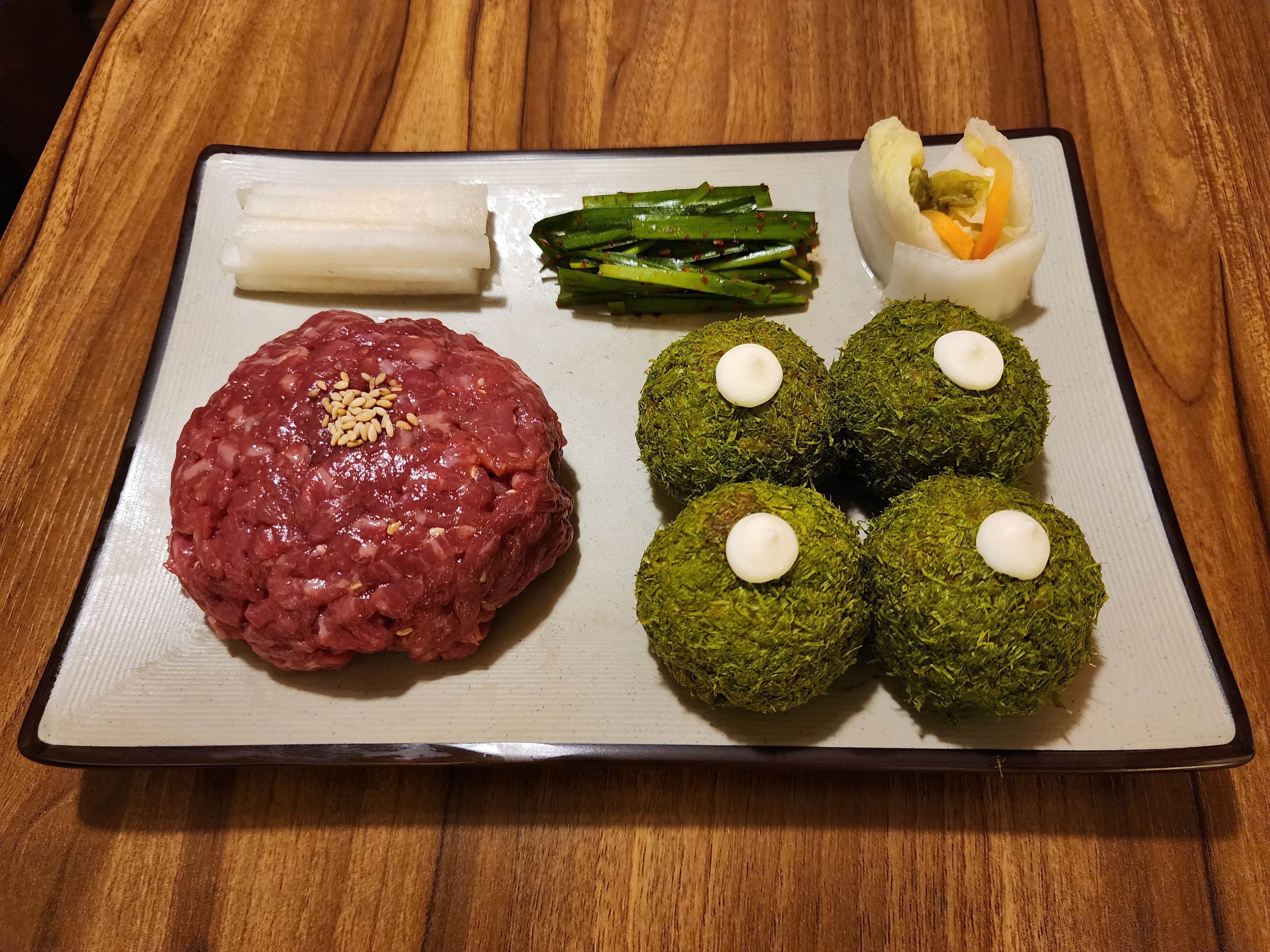 1++ Hanwoo beef tartare platter with seaweed-coated rice balls and seasonal side garnishes