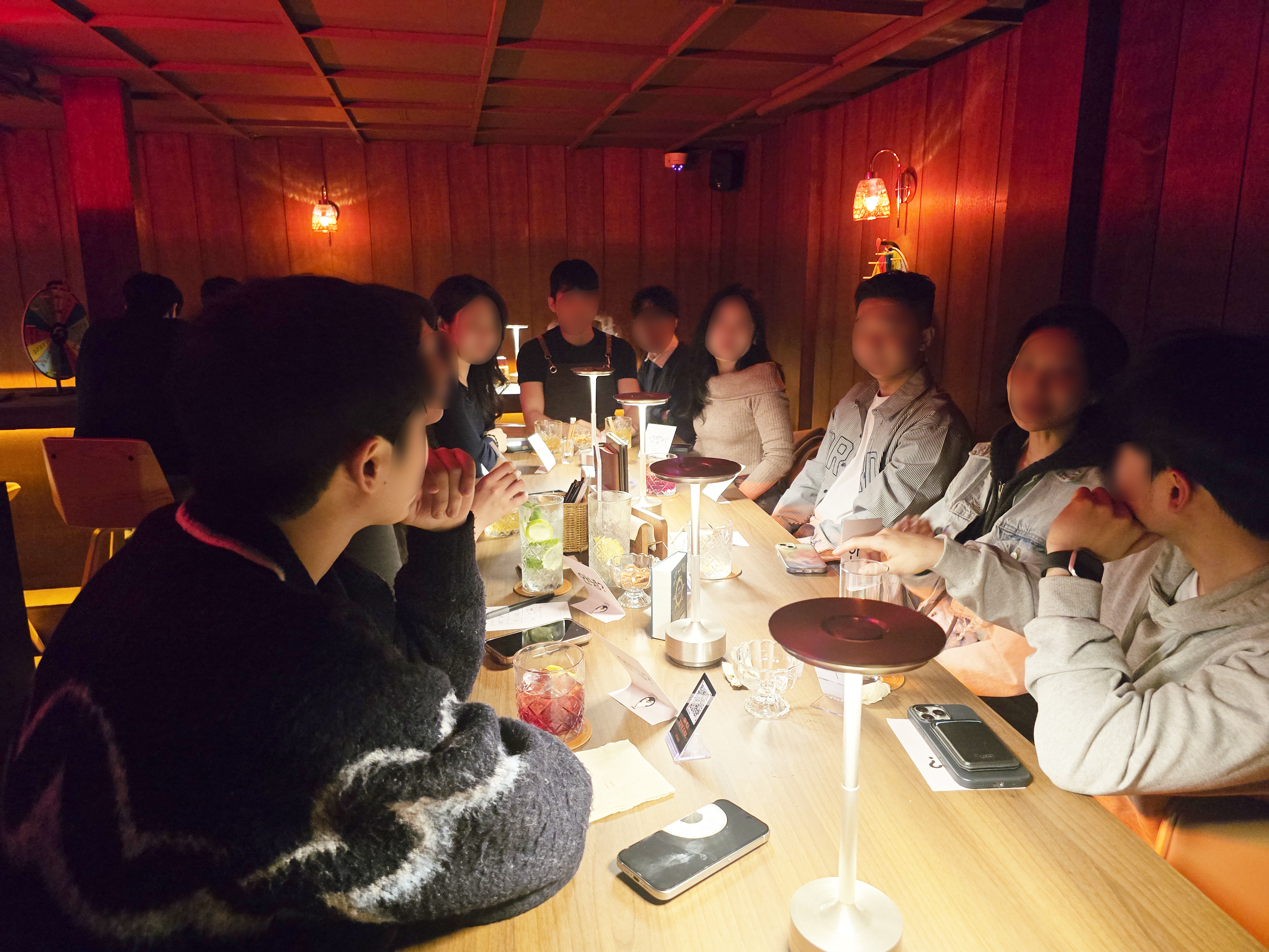 Guests enjoying cocktails around the wooden communal table