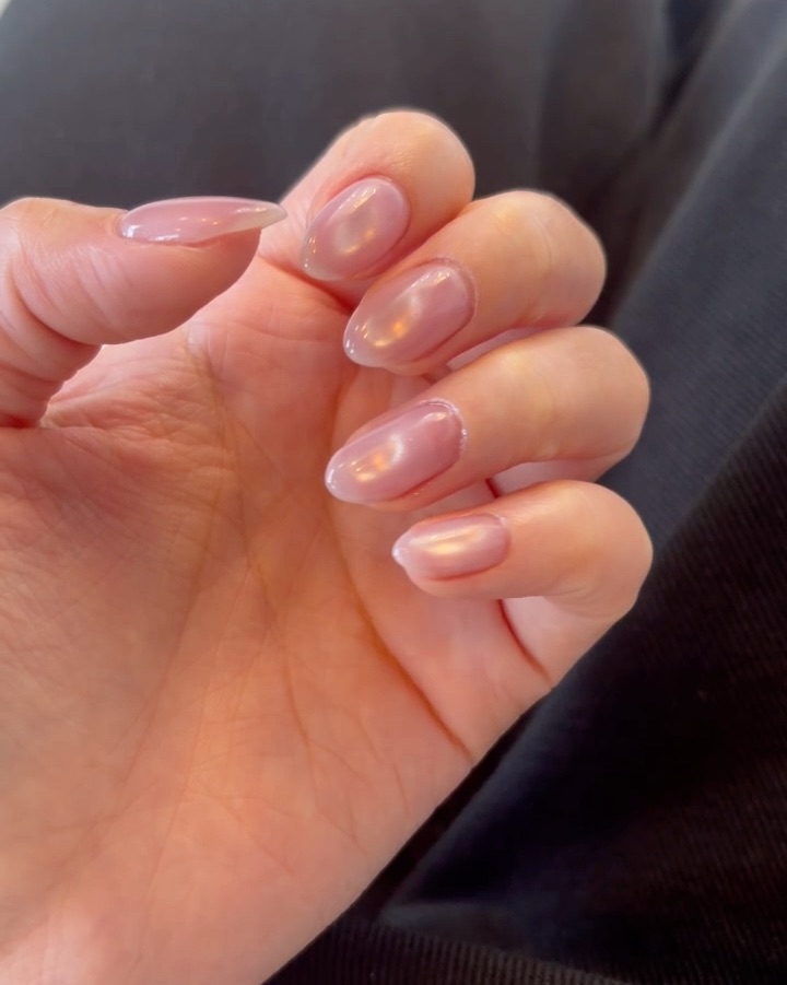 Glossy pearlescent pink syrup gel manicure on oval nails