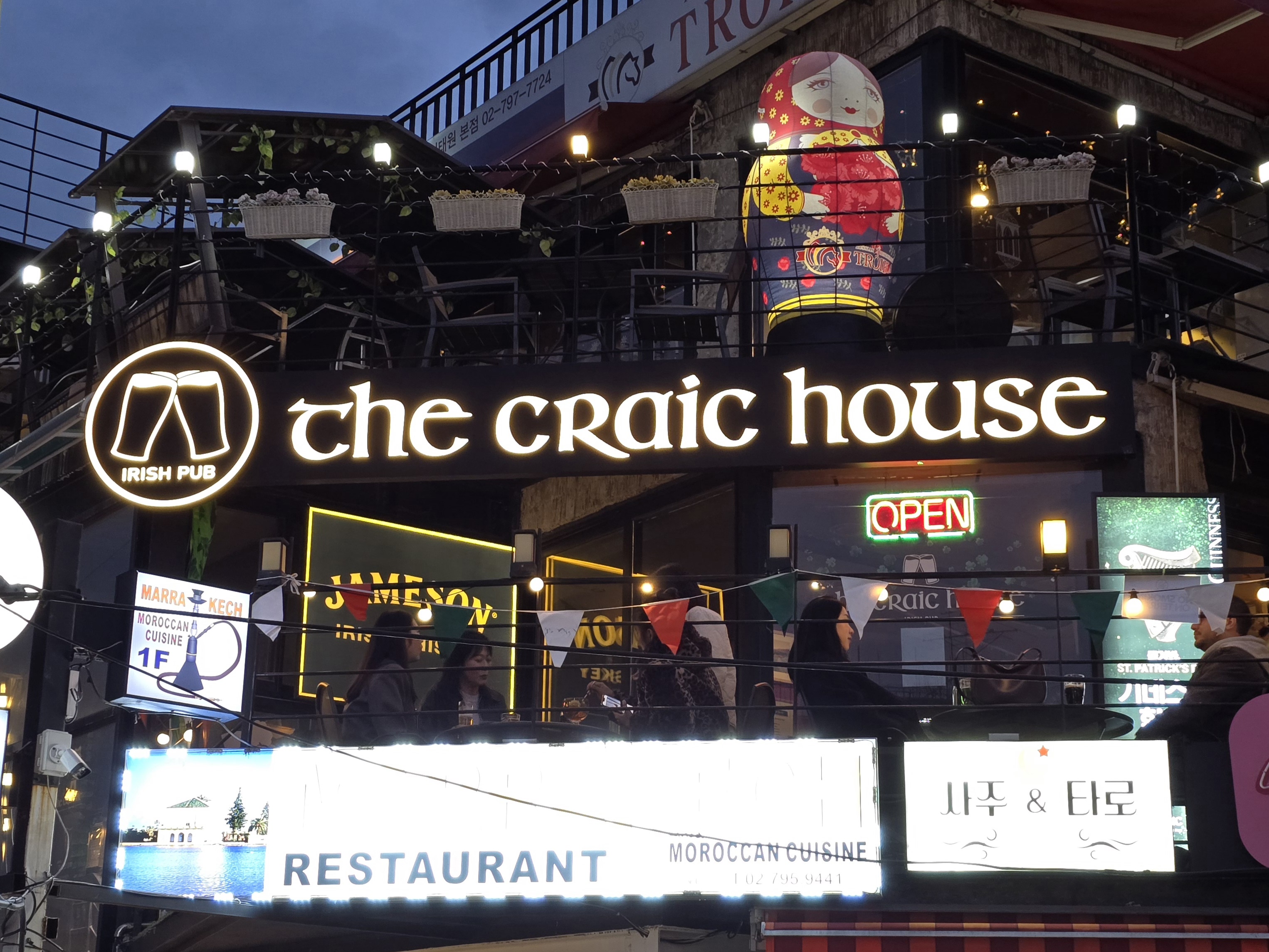 Exterior view of The Craic House 2nd-floor terrace illuminated at dusk in Itaewon