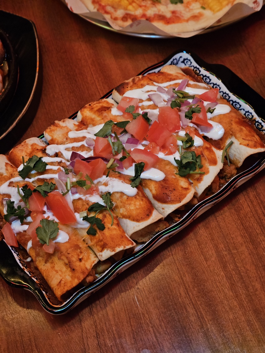 Enchiladas and cream pasta specialties topped with herbs and rich sauce