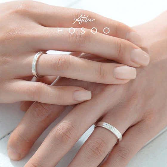 Matching silver rings on hands with minimalist aesthetic