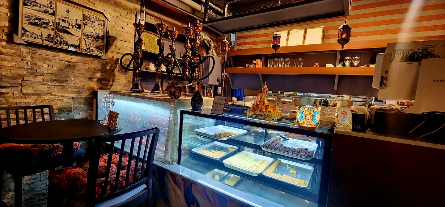 Traditional shisha pipes and sweets display inside Arabic night lounge