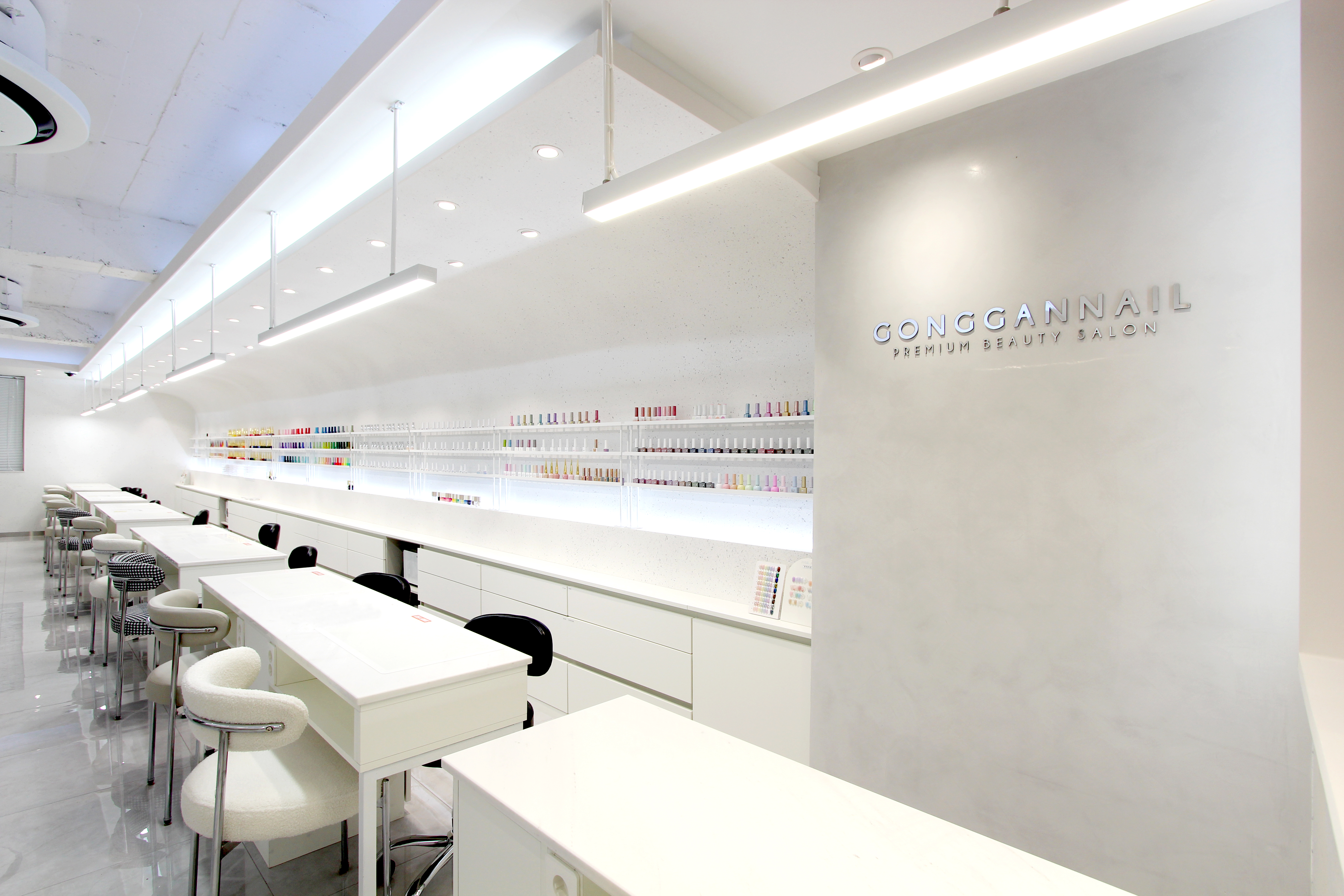Spacious, bright white nail salon interior with organized linear manicure stations
