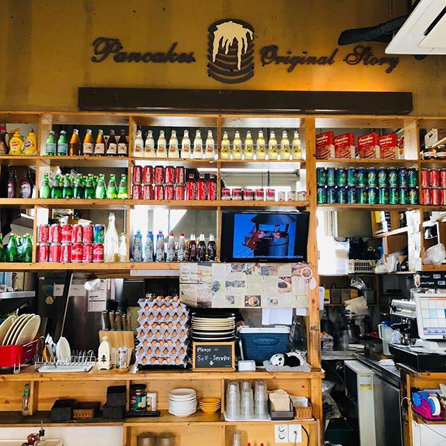 Interior counter and wooden shelving at Pancake Original Story with beverage stock and kitchen items
