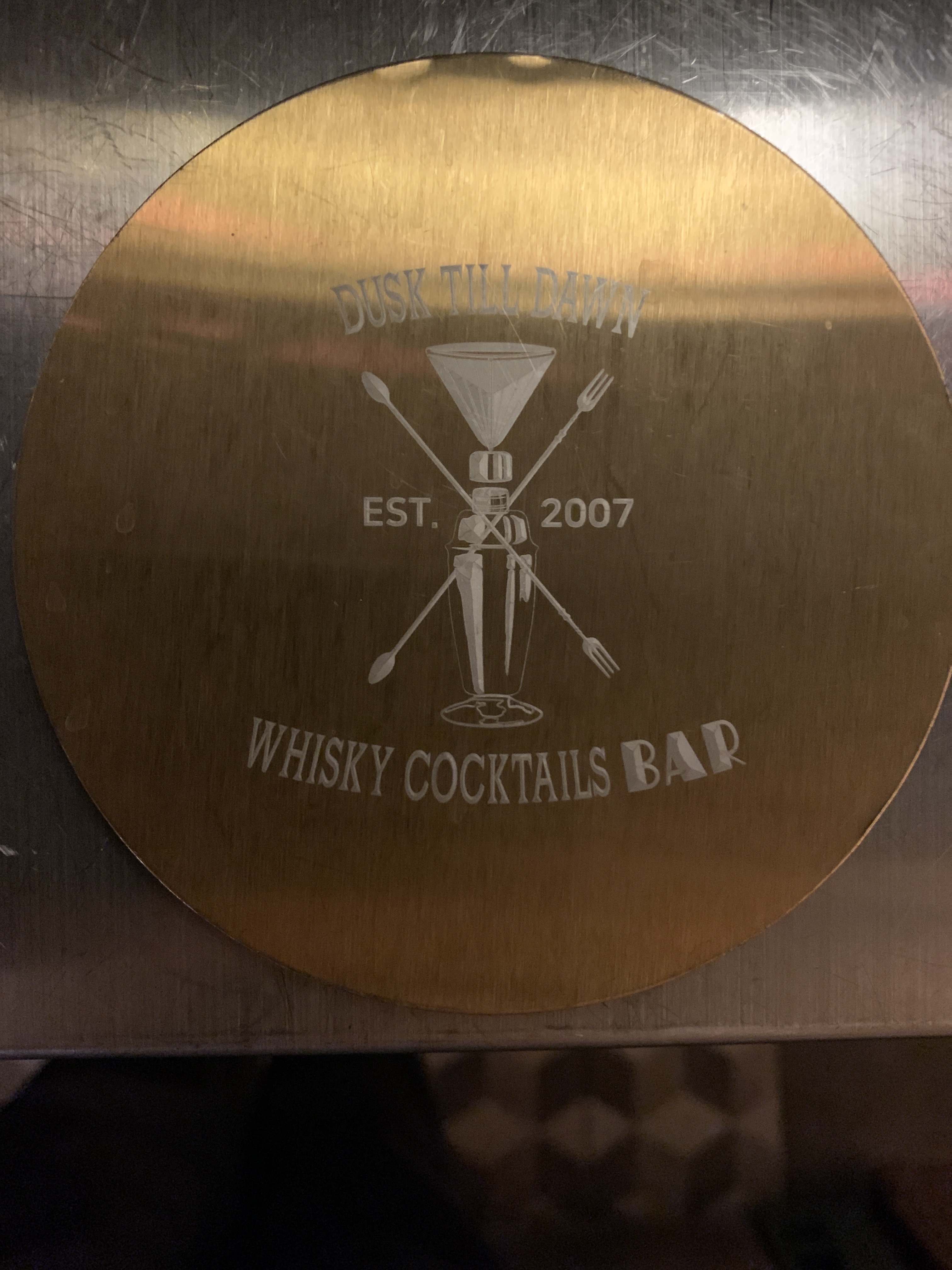 Dusk Till Dawn engraved brass bar coaster detailing established year 2007