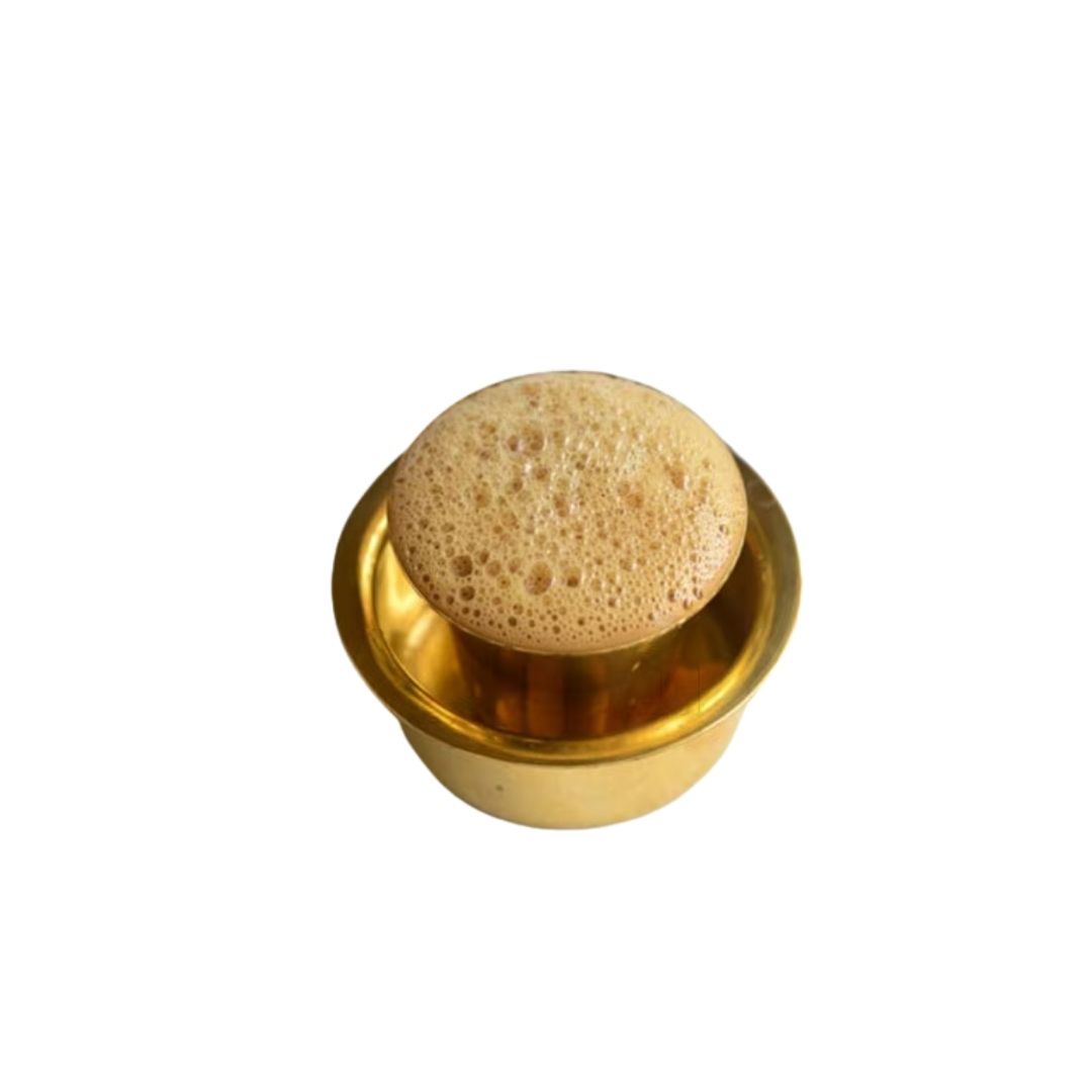 Frothy South Indian filter coffee in a traditional brass tumbler and saucer