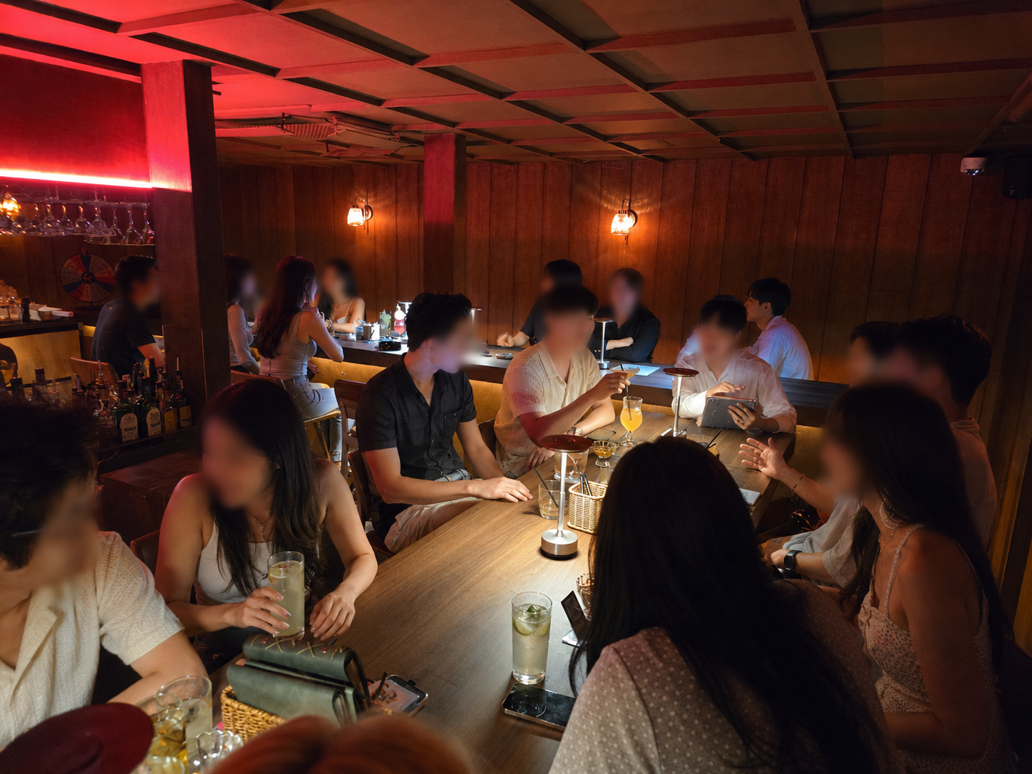 Interior of dimly lit cocktail bar with wood walls and table lamps