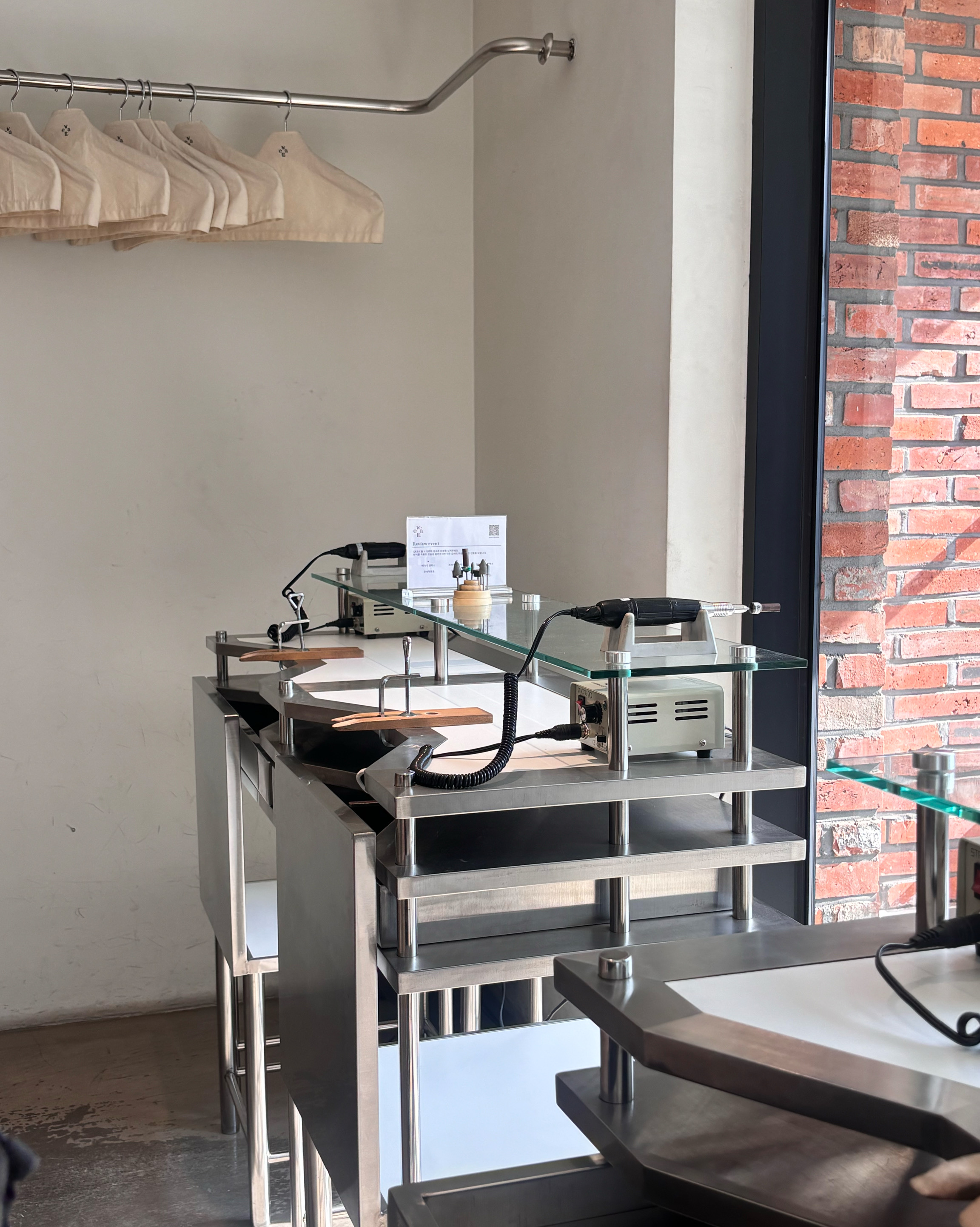 A close-up of a jewelry workstation at Weatt Seongsu craft studio featuring metal tables and tools