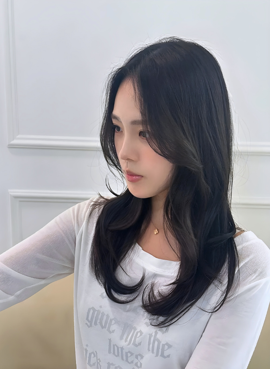 Long layered wavy hair styling in modern salon setting