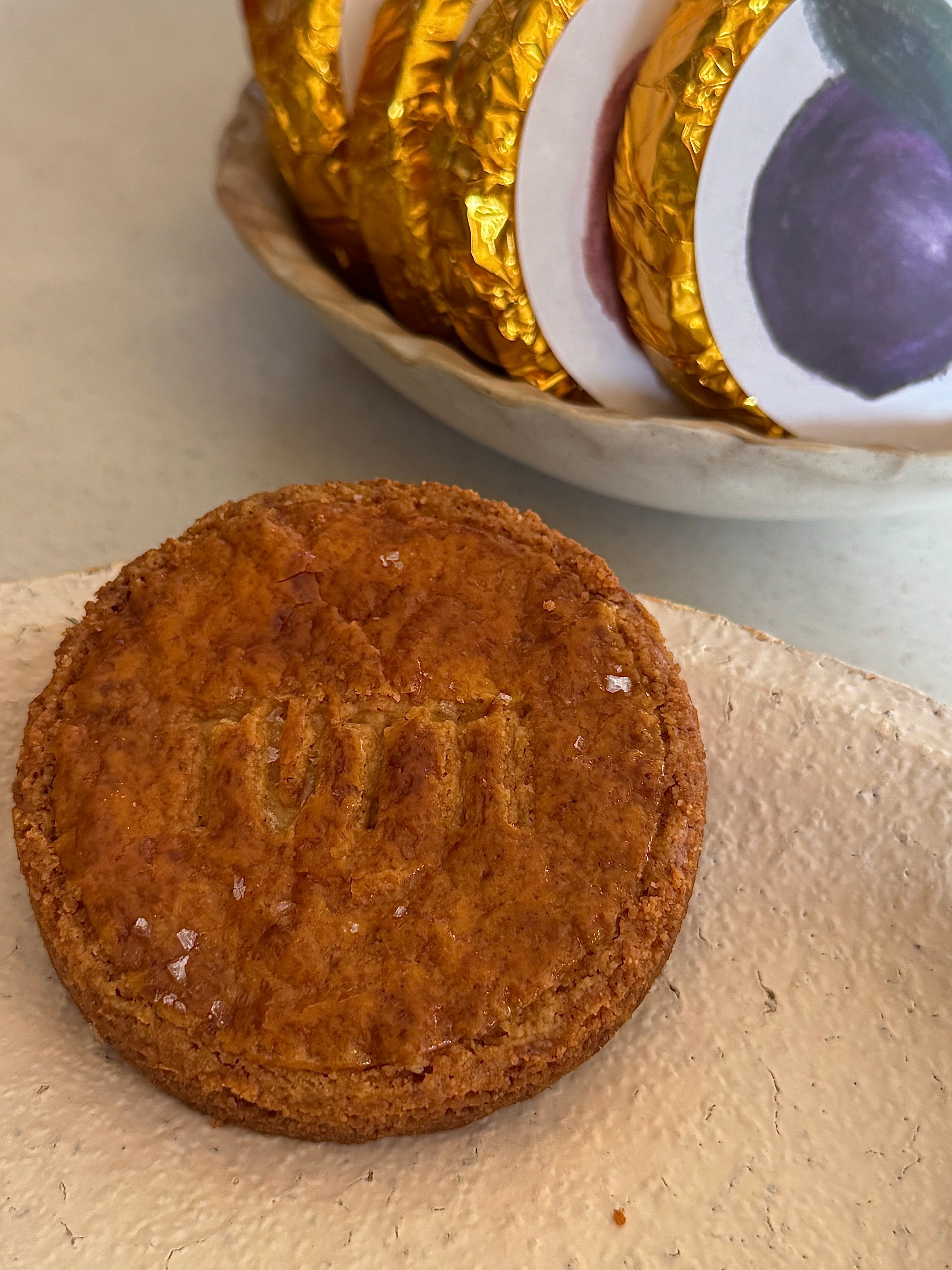 Fresh golden-brown baked pastry sprinkled with sea salt on rough stone plate