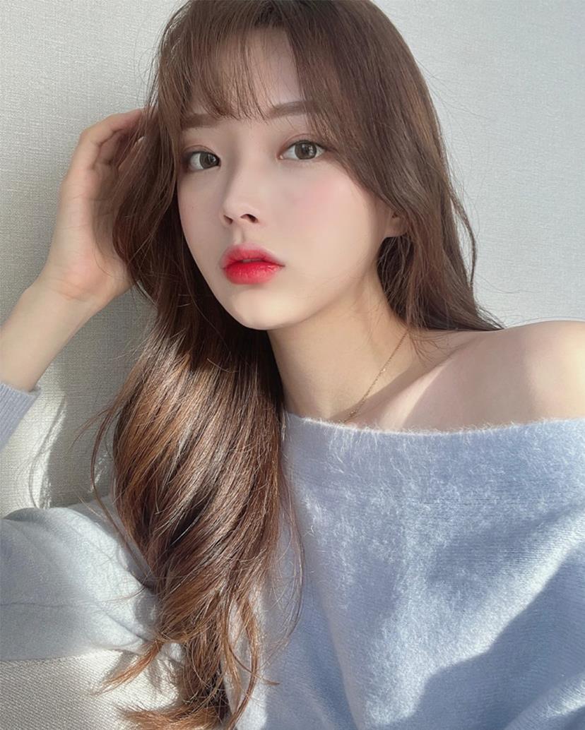 Young woman with long wavy brown hair and natural layering