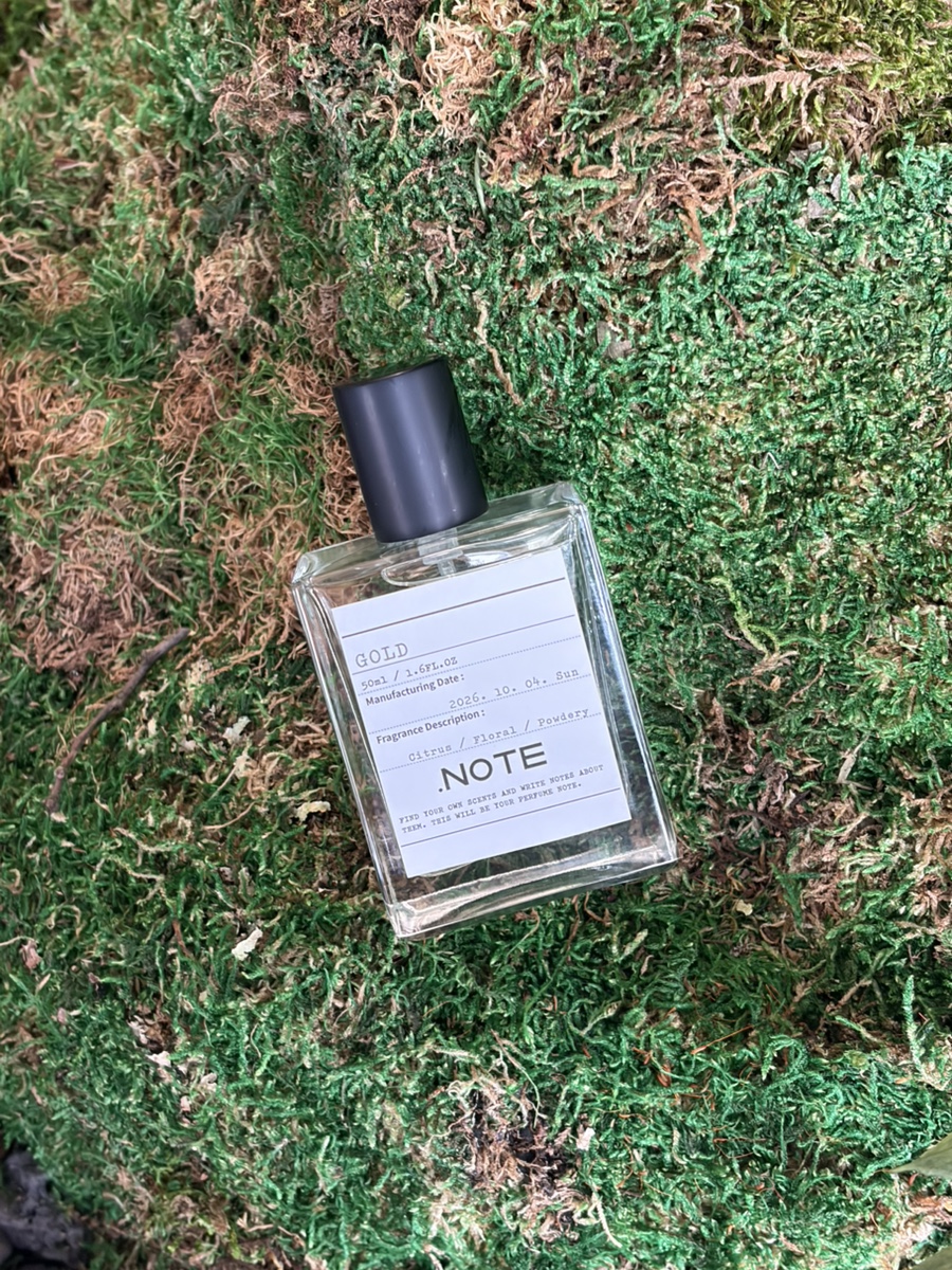 Custom glass perfume bottle centered on organic moss surface