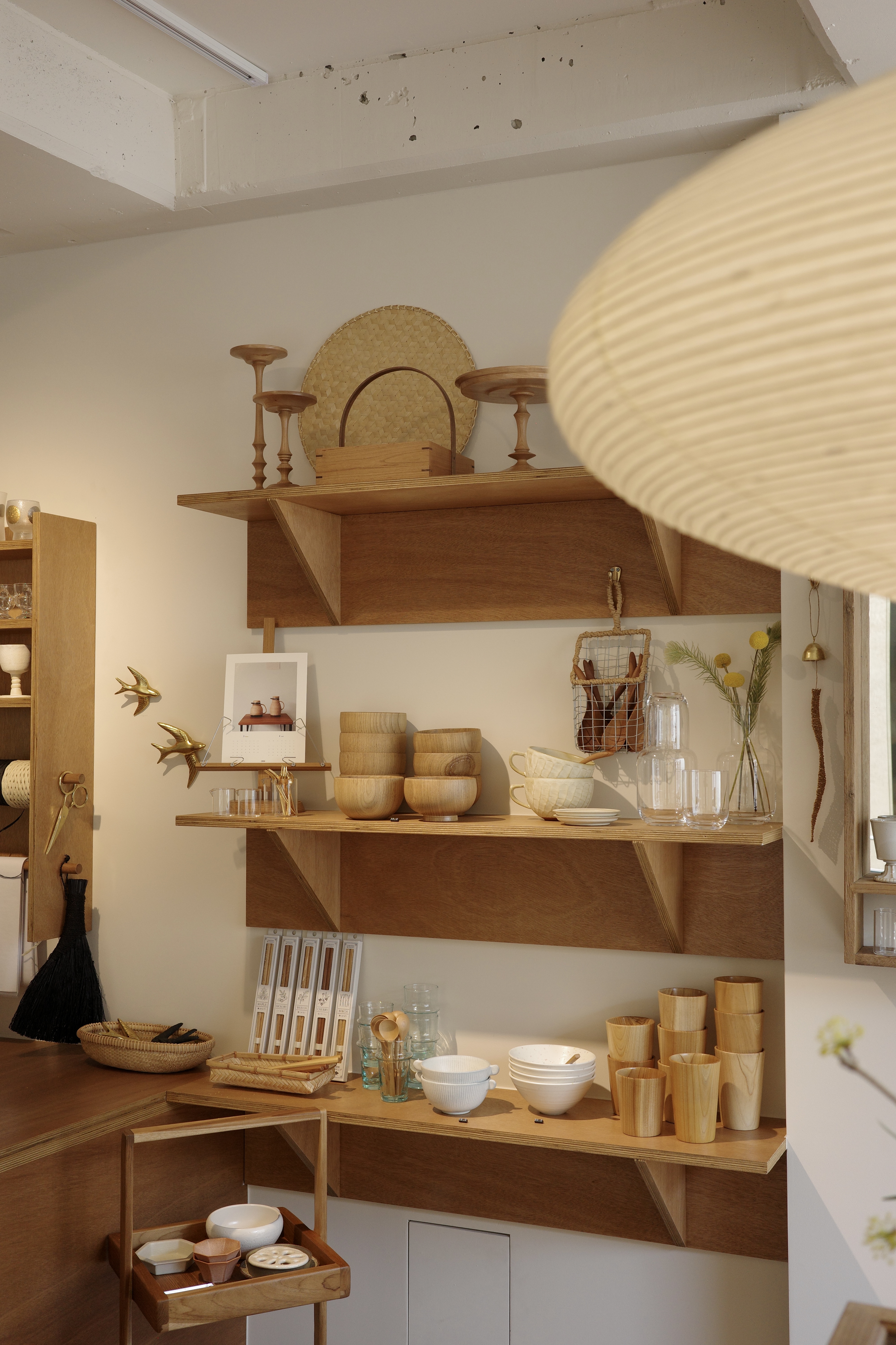 Wooden shelves displaying ceramic mugs and kitchenware.