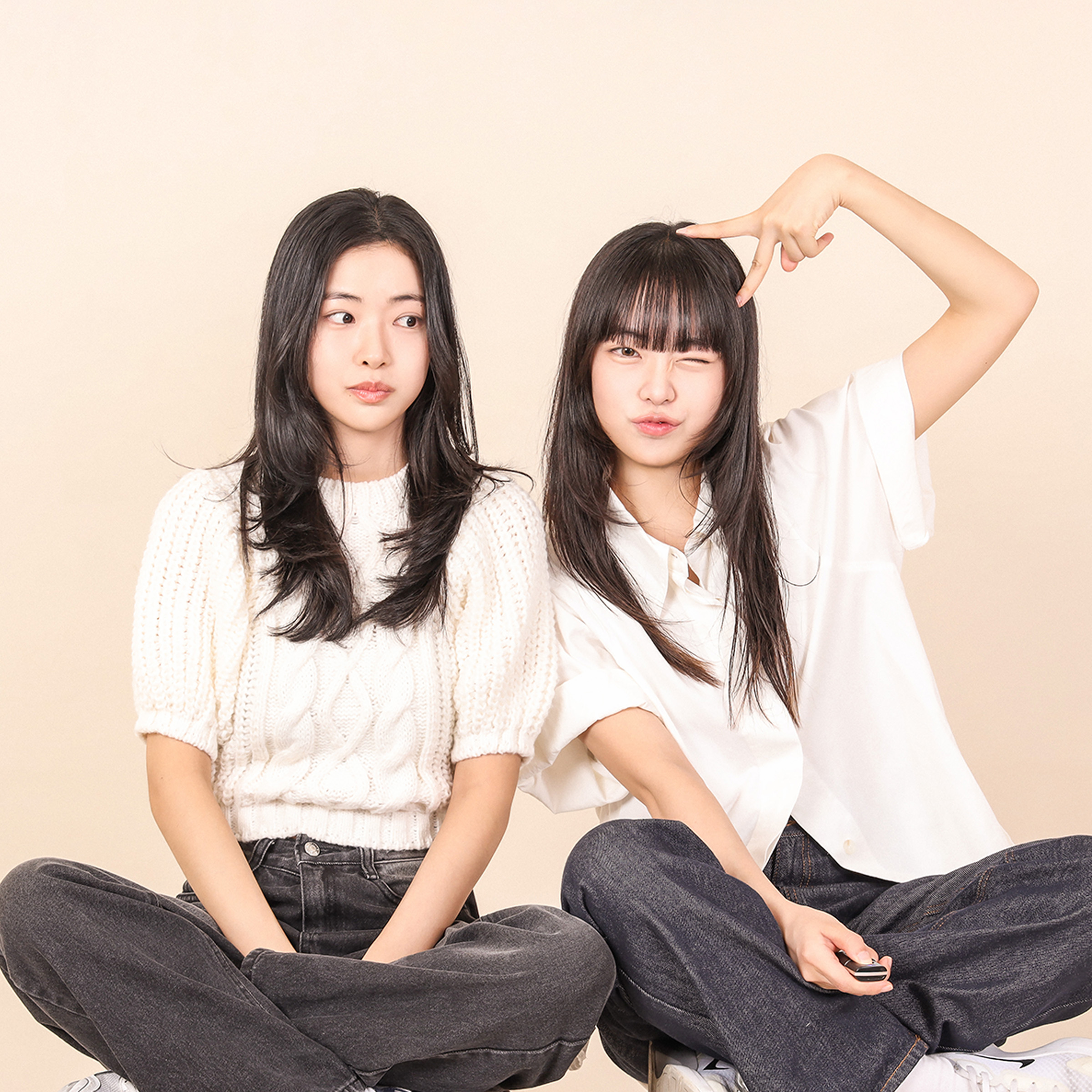 Two women sitting cross-legged in the studio