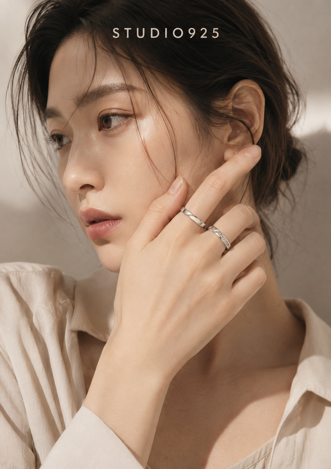 Close-up portrait of handcrafted silver rings worn with soft studio lighting