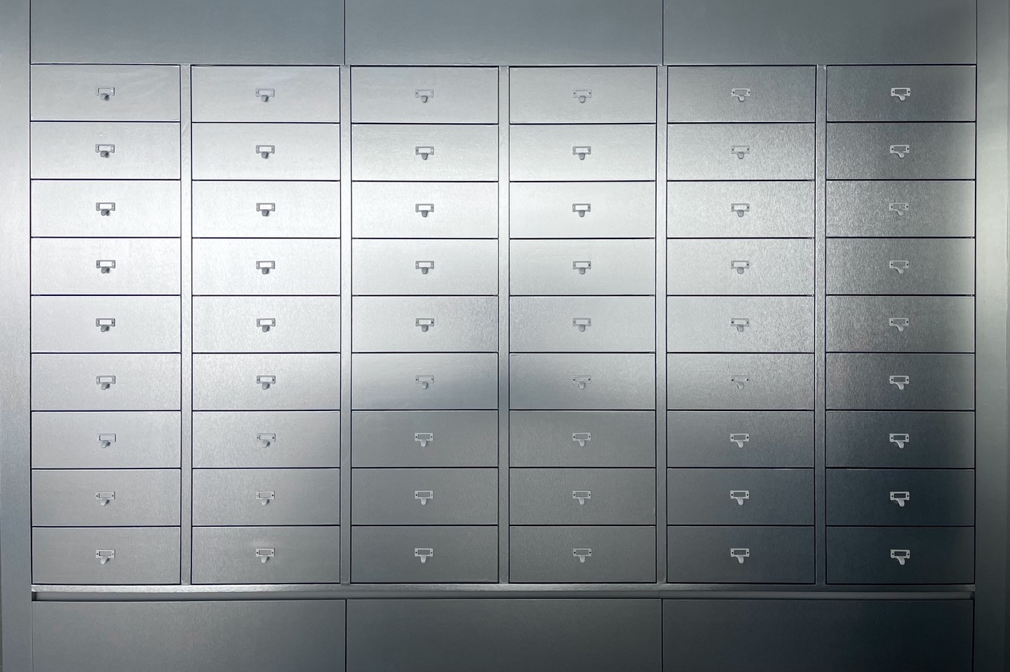 Grid of organized matte grey metal storage drawers with label holders
