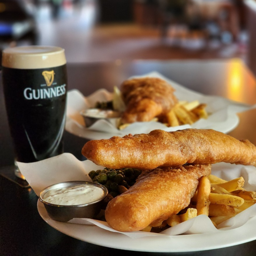 Classic fish and chips served with peas, tartar sauce, and a pint of stout