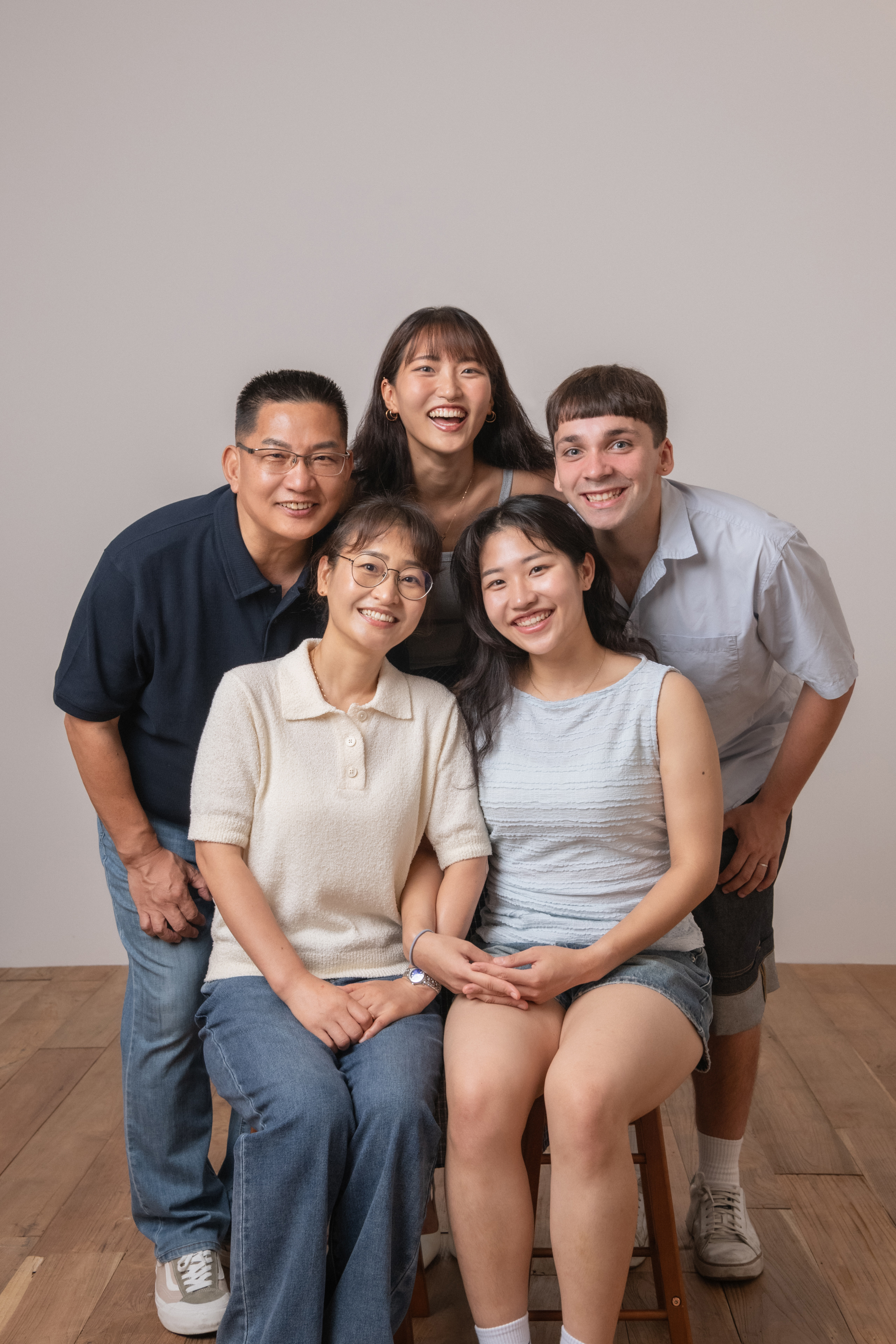 A group portrait of five people smiling together in a studio setting
