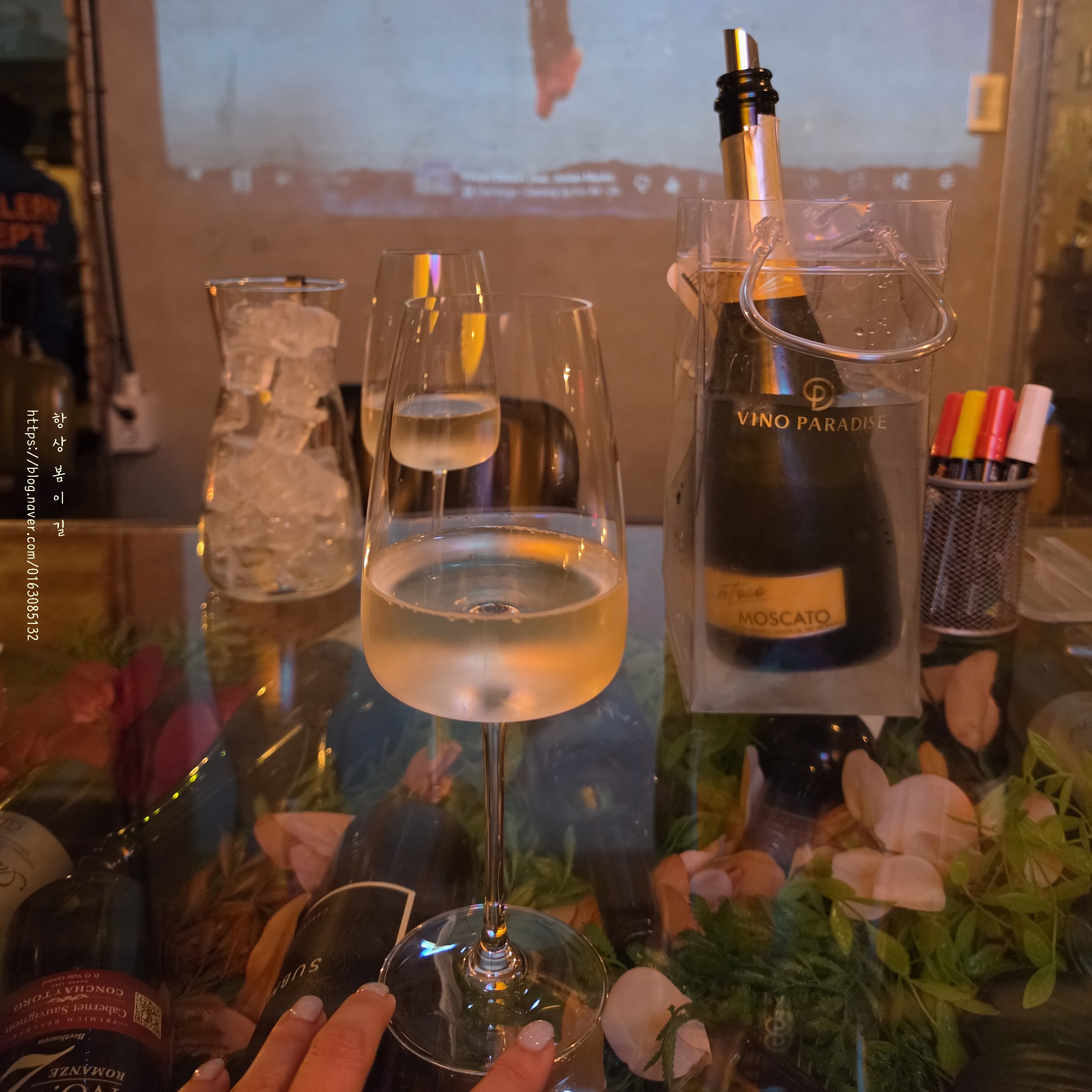 Sparkling wine glass and chilled bottle in ice bucket on transparent table