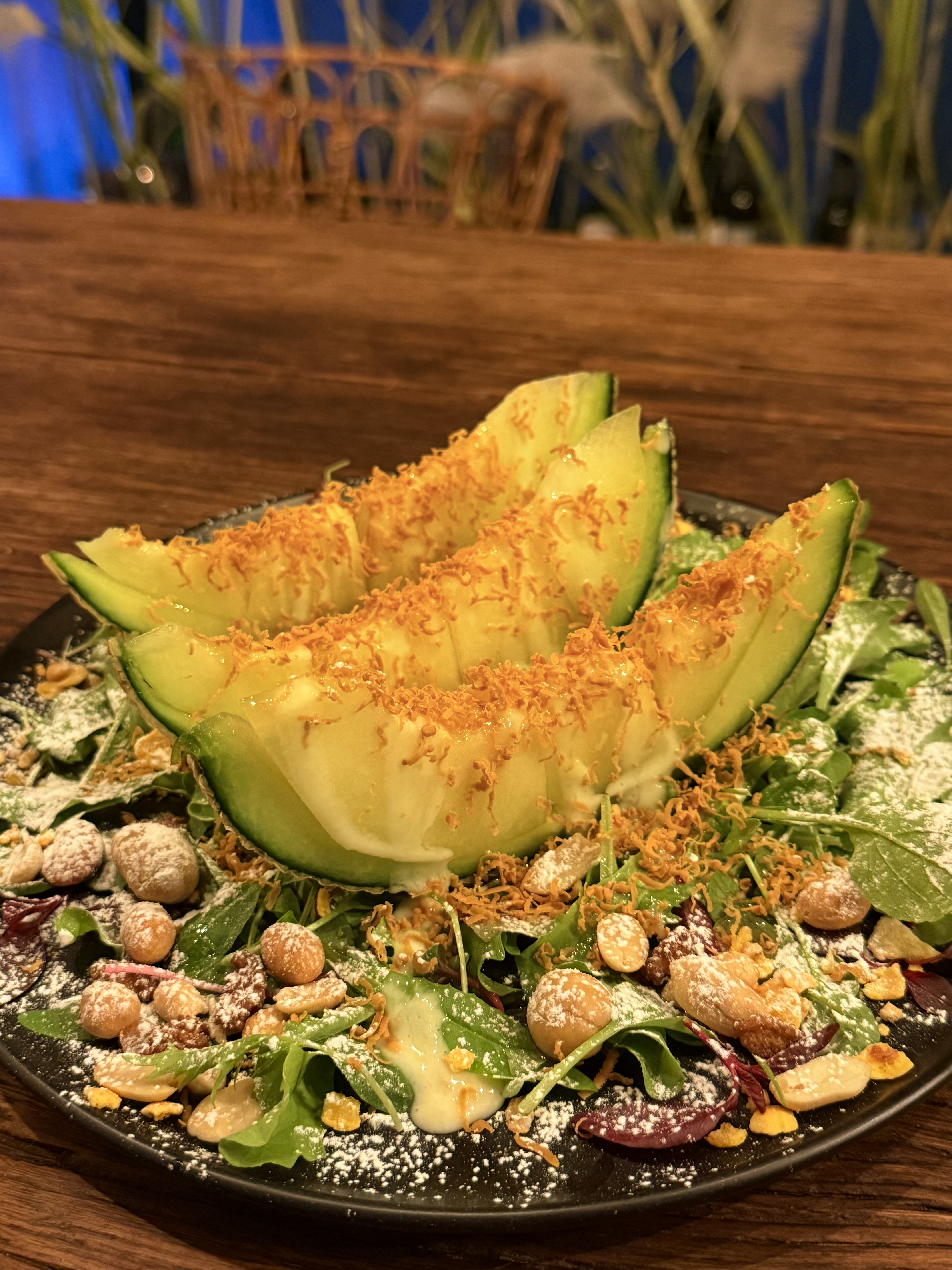 Thick melon slices with fresh greens and roasted nuts