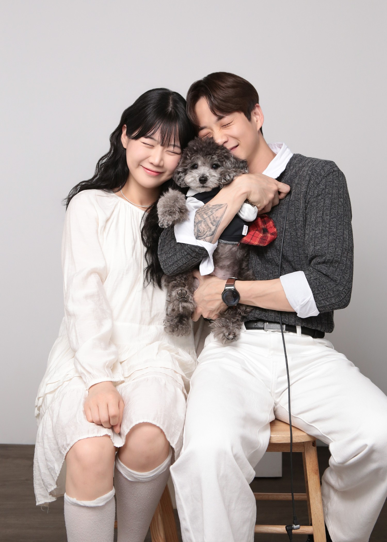 Couple seated together with their poodle pet