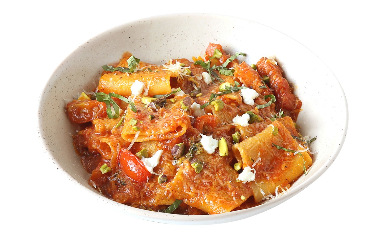 Rigatoni pasta with rich tomato sauce, pistachio crumbs, and fresh basil