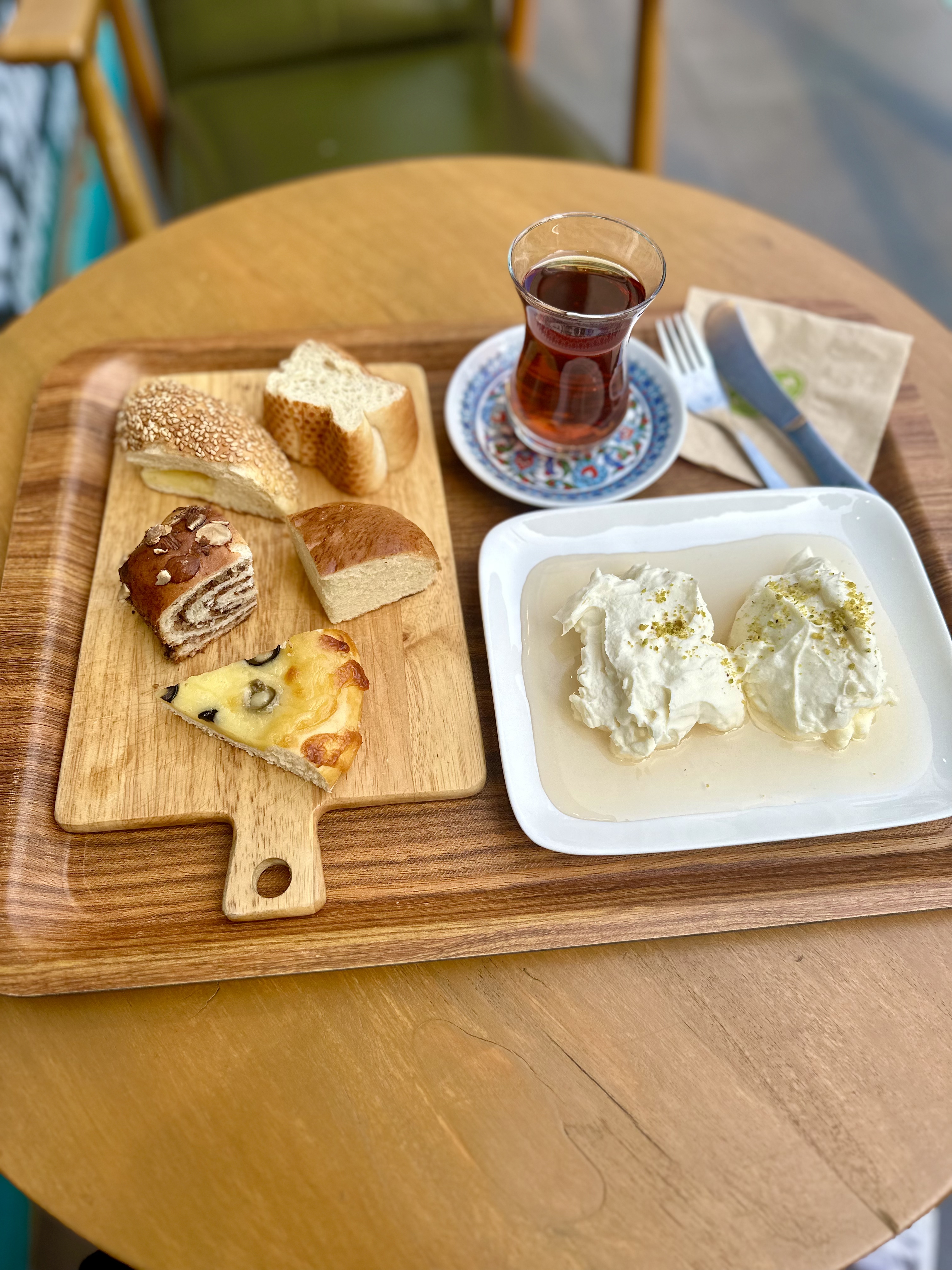 Serving tray with bread, kaymak cream in honey, and Turkish tea