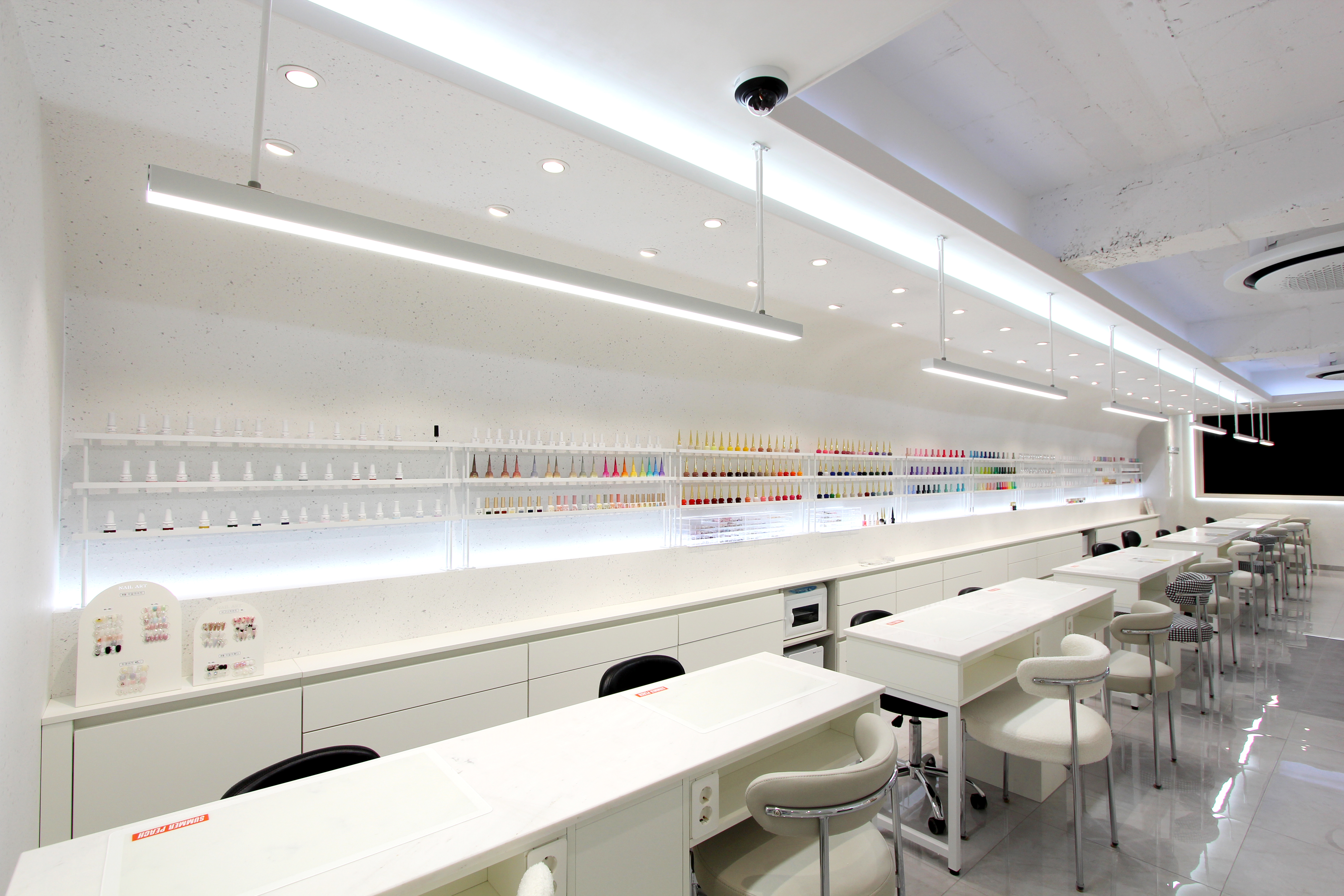 Linear shelving displays showcasing a vast gradient of nail polish colors in the salon