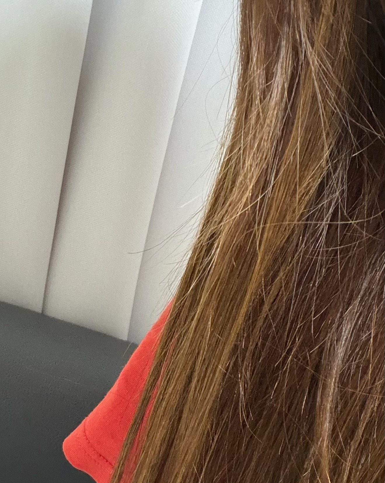 Close-up of long straight light brown hair strands displaying silk texture